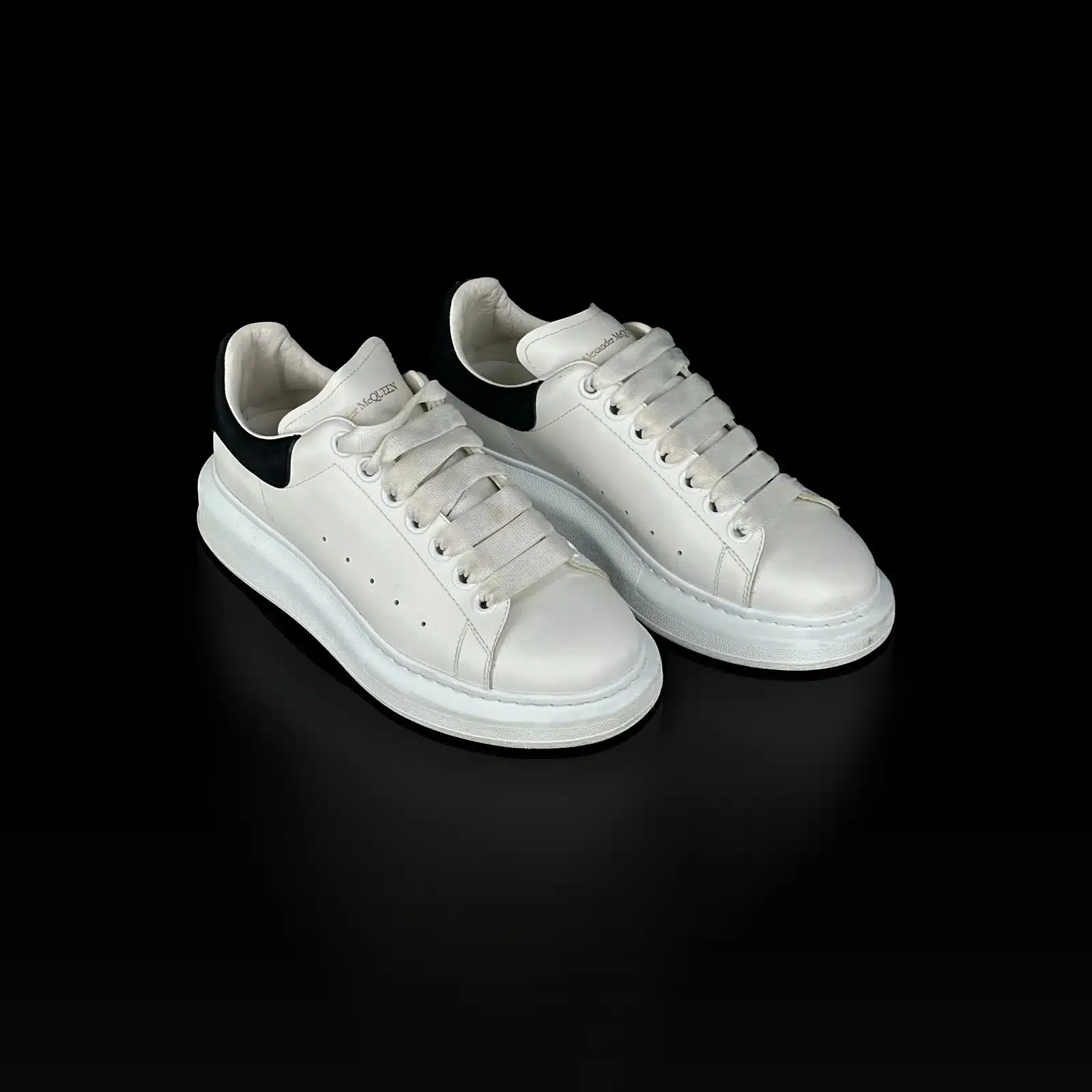 Paire de baskets Alexander McQueen Oversized en cuir blanc et daim noir, vue de trois quarts