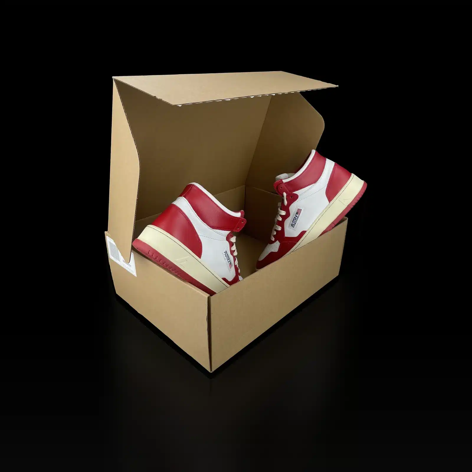 Pair of Autry Medalist Mid sneakers in white and red shown in a box