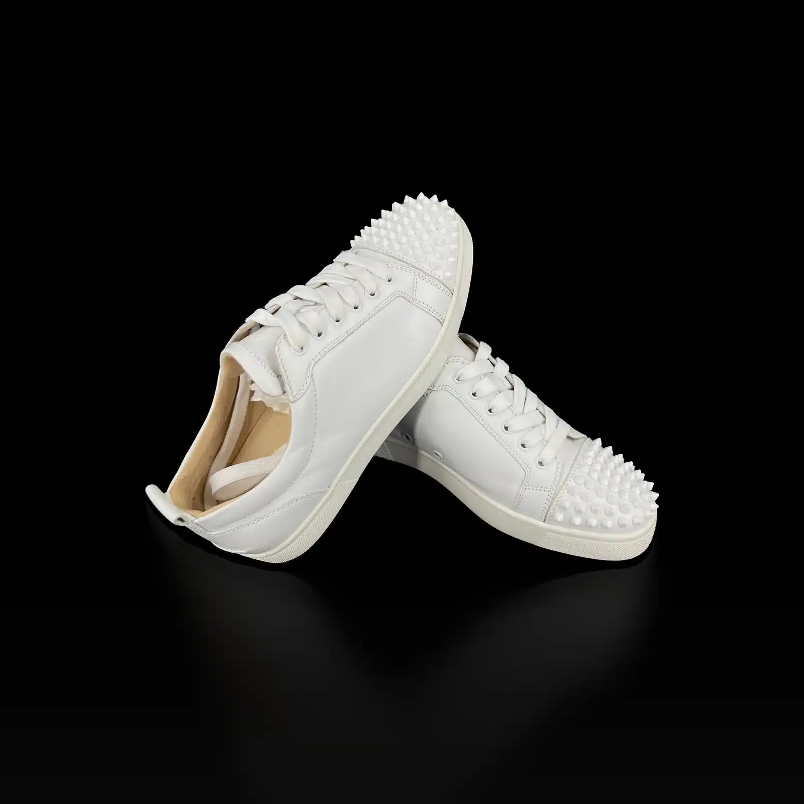 Baskets Christian Louboutin Louis Junior Spikes blanches posées l'une sur l'autre