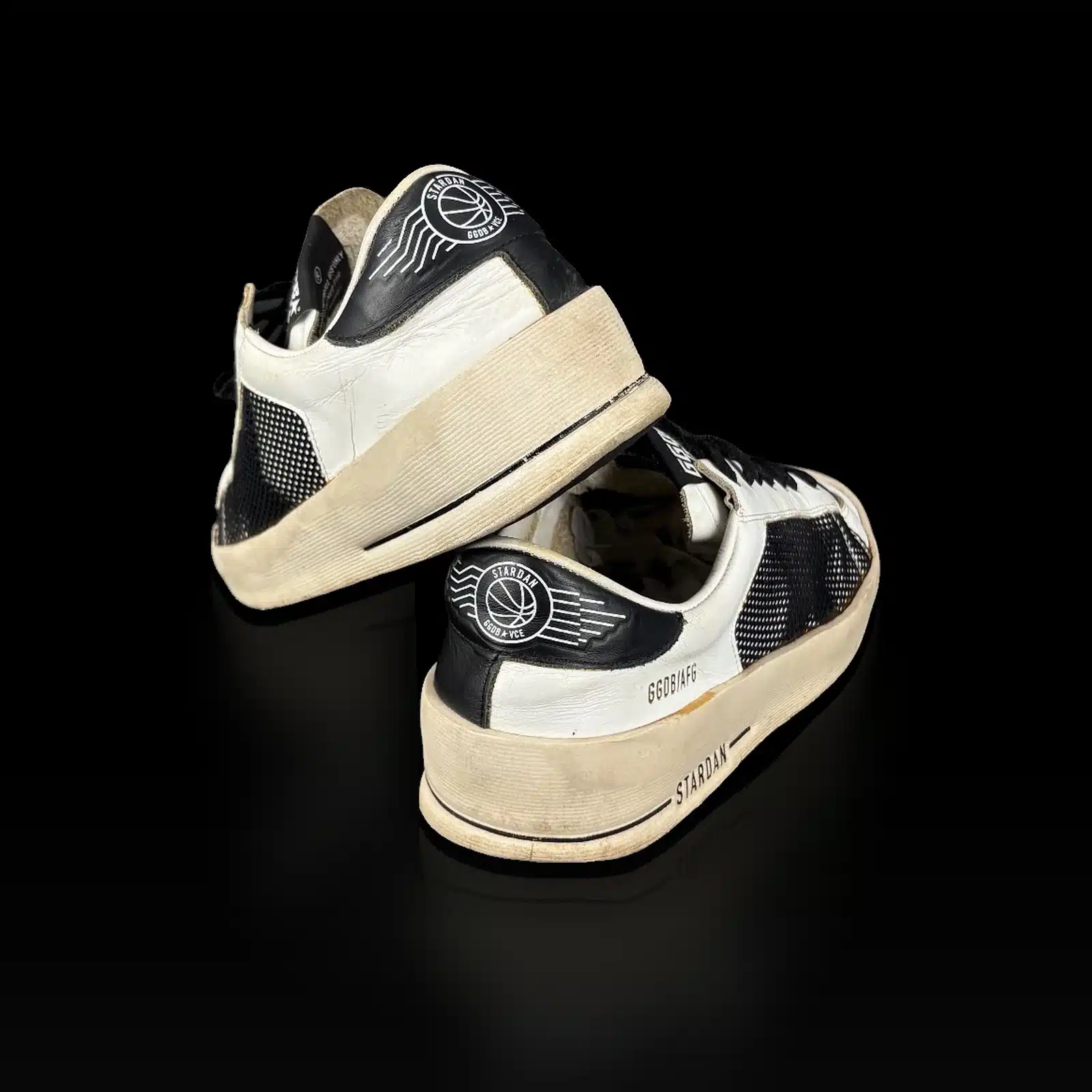 Paire de baskets Golden Goose Stardan blanc et noir posée dans sa boîte d'expédition