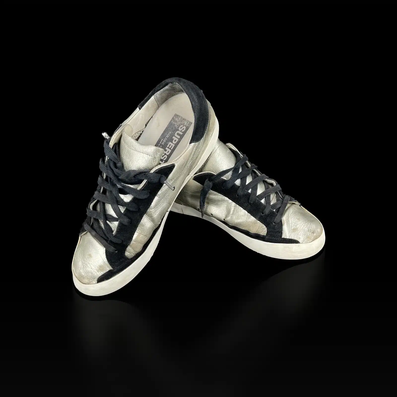 Paire de baskets Golden Goose Super-Star argentées et noires, vue de trois quarts