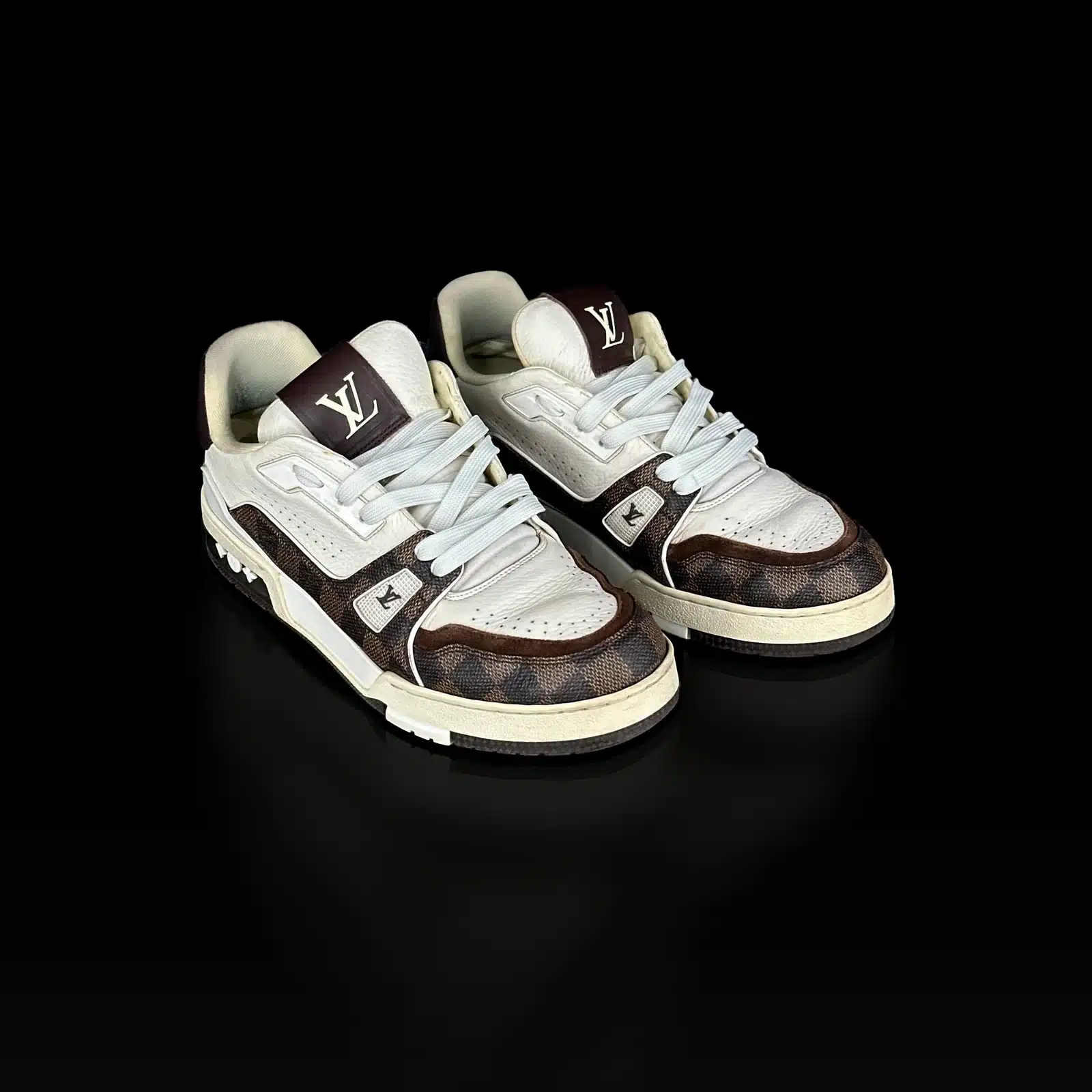 Paire de baskets Louis Vuitton Trainer en cuir blanc et toile Damier Ébène, vue de trois quarts avant