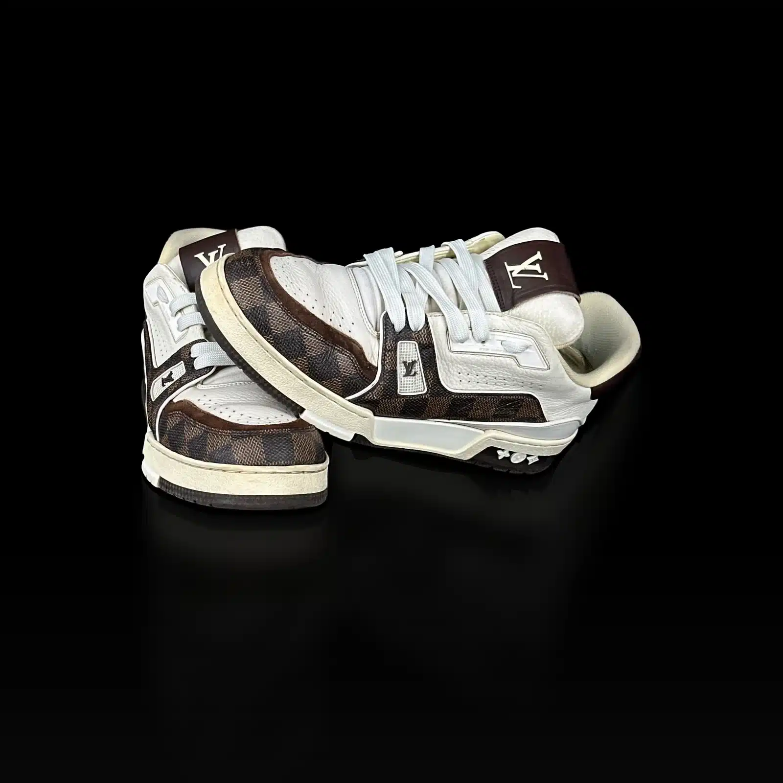 Baskets Louis Vuitton Trainer Damier Ébène posées l'une sur l'autre