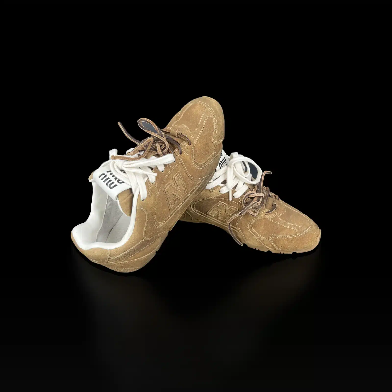 Paire de baskets Miu Miu x New Balance 530 SL en daim camel, l'une posée sur l'autre