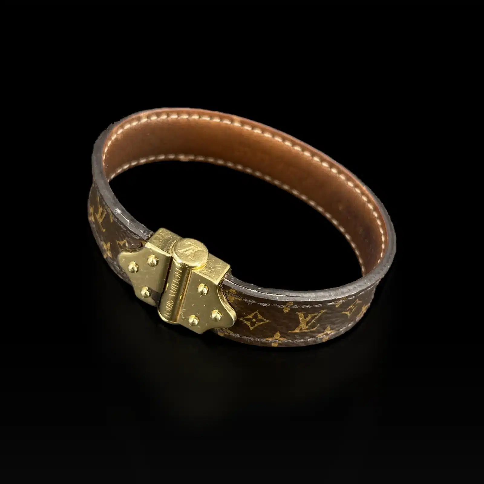 Fermoir doré clouté gravé Louis Vuitton du bracelet Nano Monogram, sur fond noir