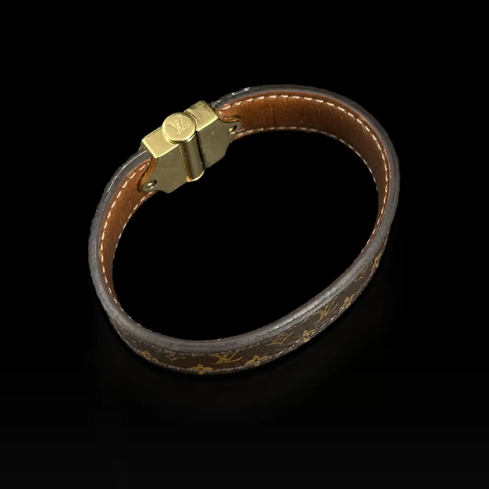 Intérieur du fermoir et cuir naturel du bracelet Louis Vuitton Nano Monogram, sur fond noir