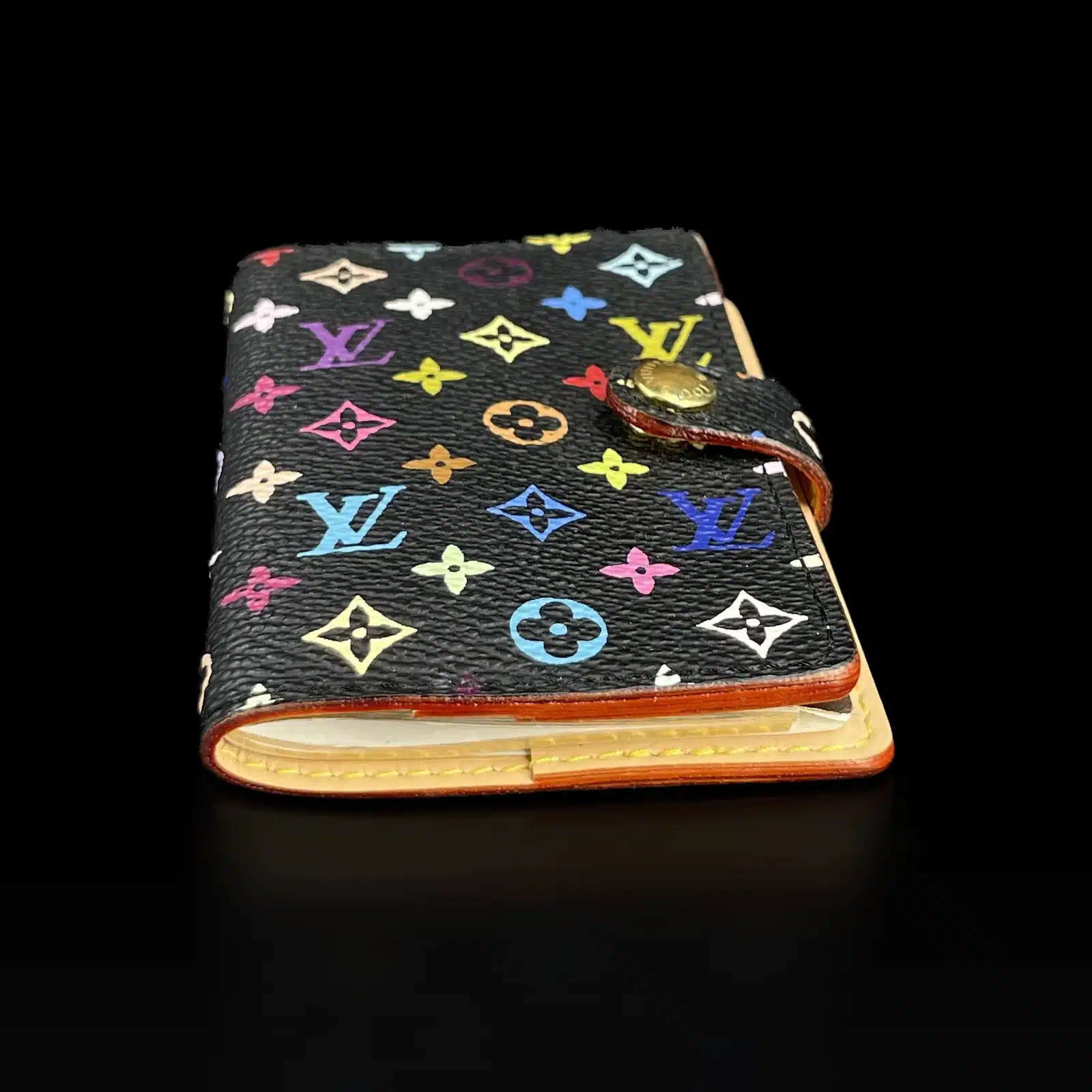 Carnet de Bal Louis Vuitton Multicolore posé à plat, tranche en cuir naturel