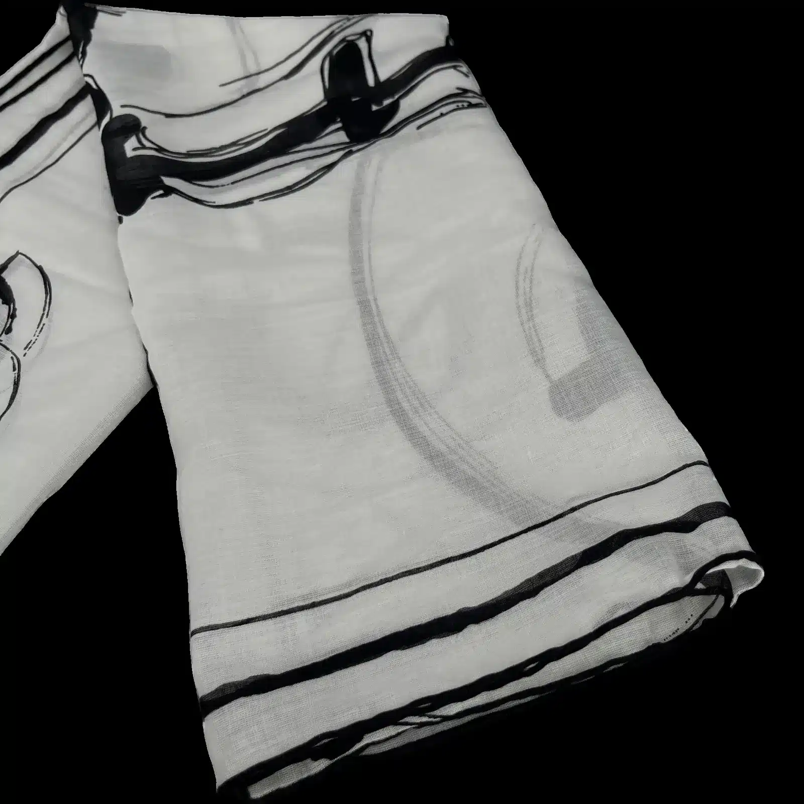 Pañuelo Chanel blanco doblado, borde negro y estampado de tinta