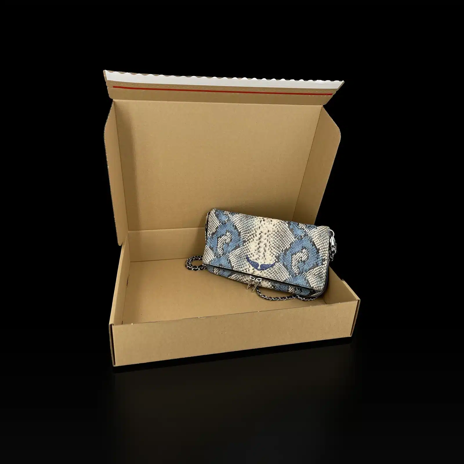 Pochette Zadig et Voltaire Rock effet python bleu posée dans son carton