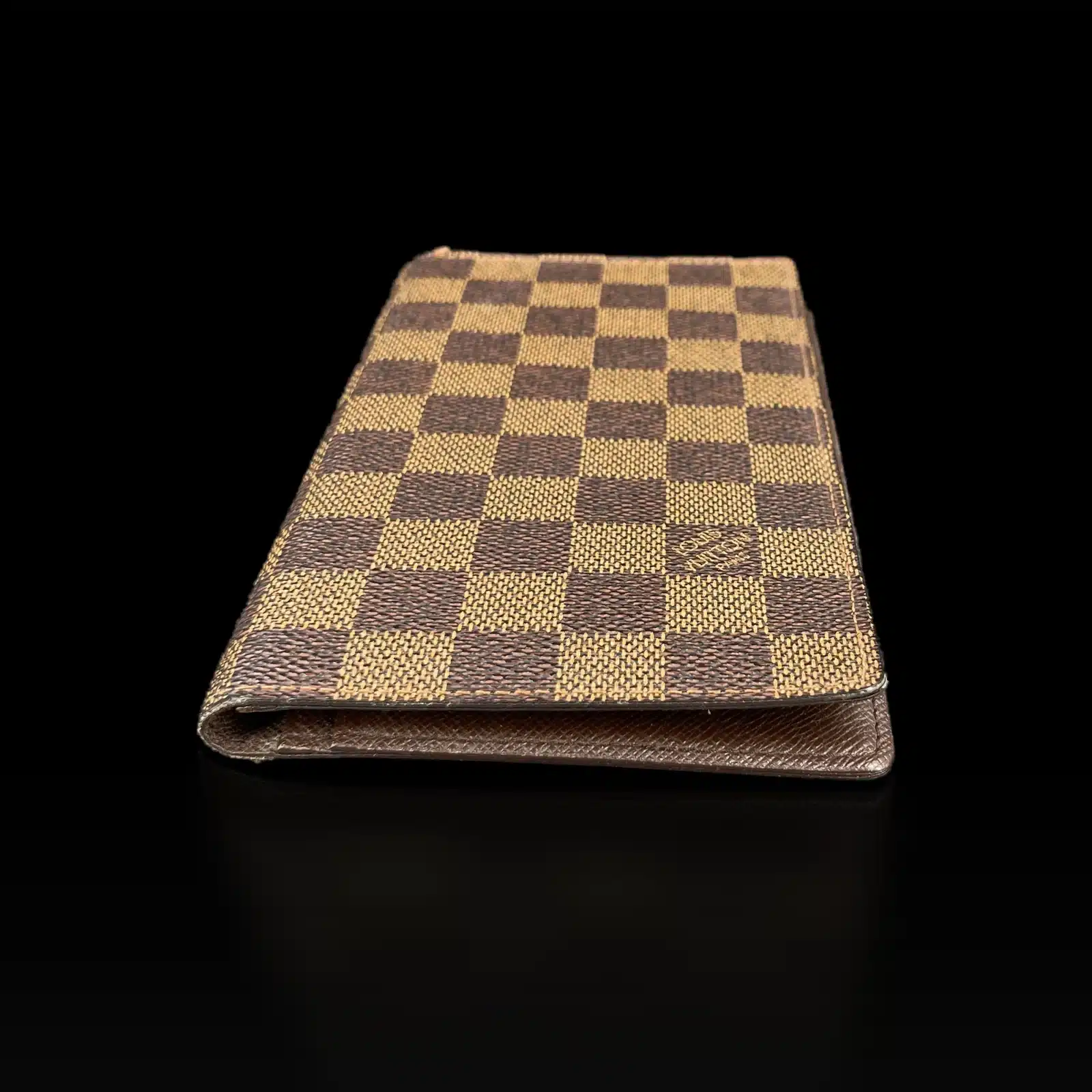 Portefeuille Louis Vuitton Damier Ébène posé à plat, logo Louis Vuitton déposé