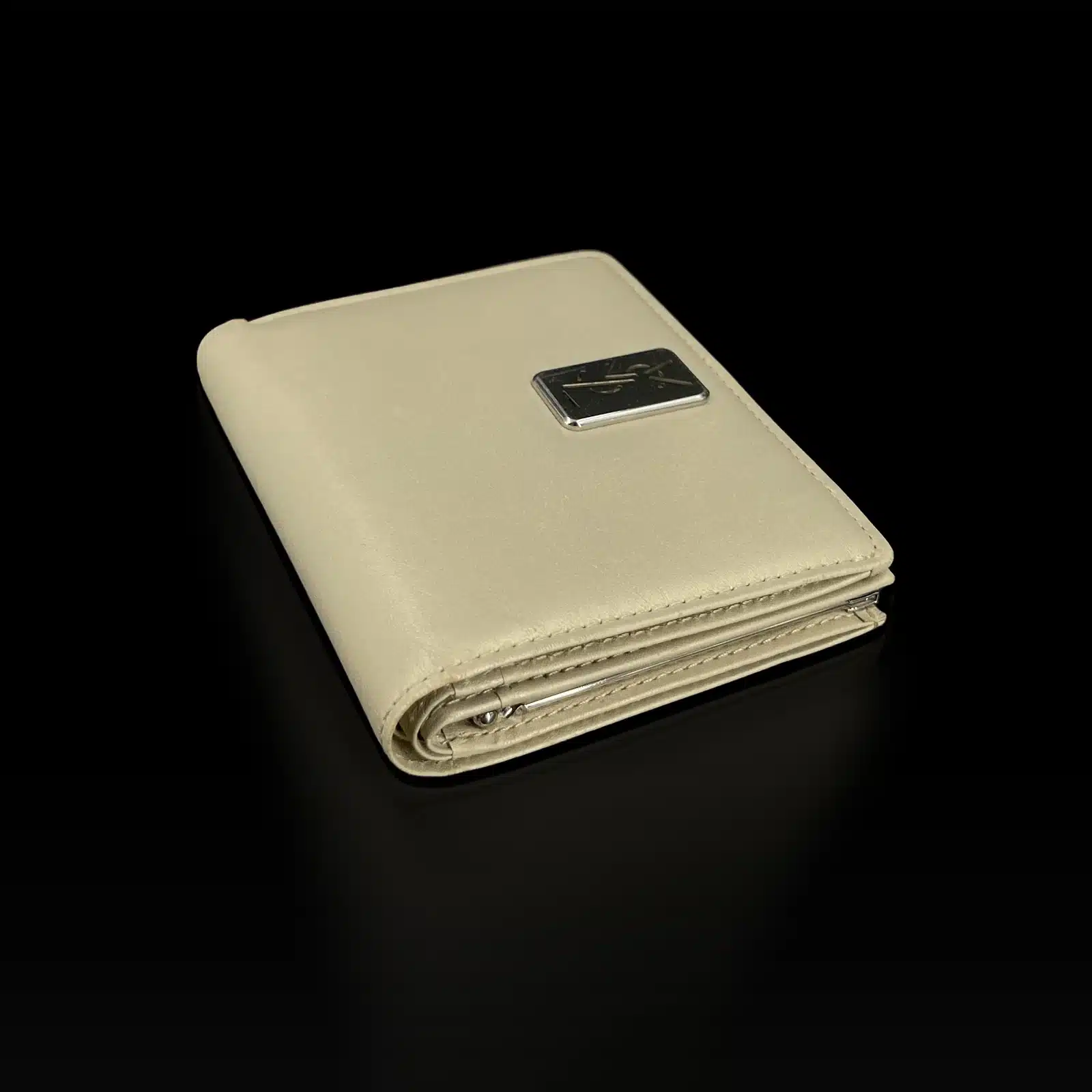 Portefeuille Yves Saint Laurent beige posé à plat, vue de côté avec le fermoir du porte-monnaie