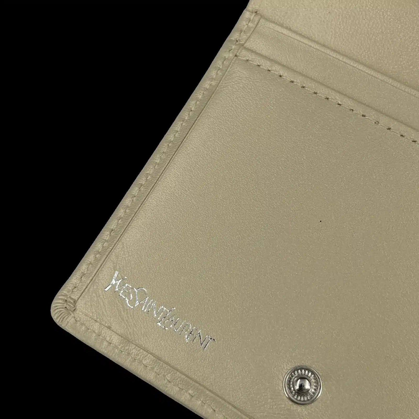 Intérieur du portefeuille Yves Saint Laurent, signature argentée et bouton pression
