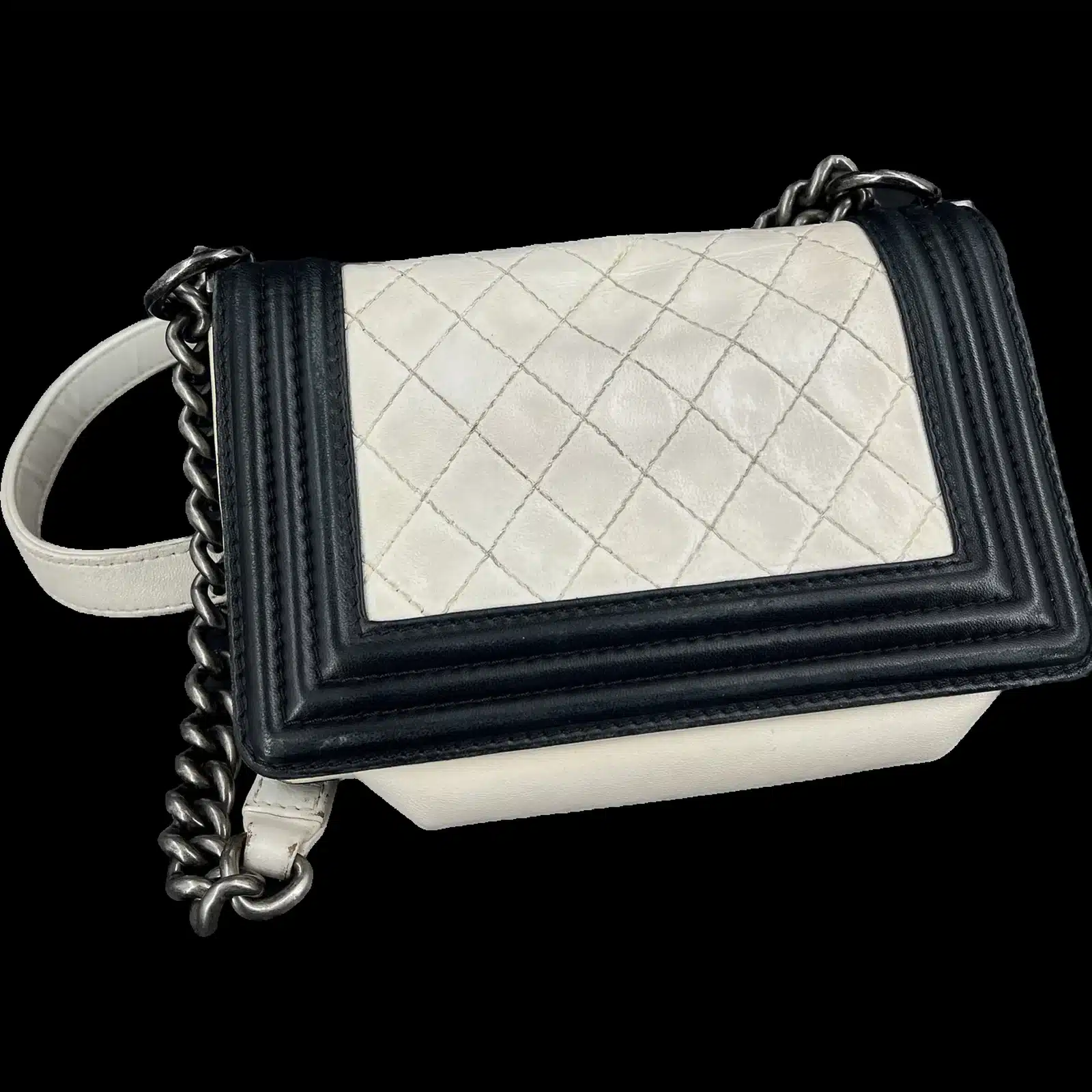 Sac Chanel Boy mini blanc et noir vu de trois quarts, chaîne et épaulière