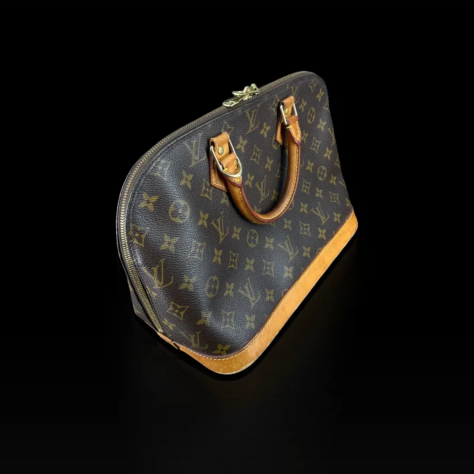 Sac Louis Vuitton Alma Monogram vu de trois quarts, poignées en cuir naturel
