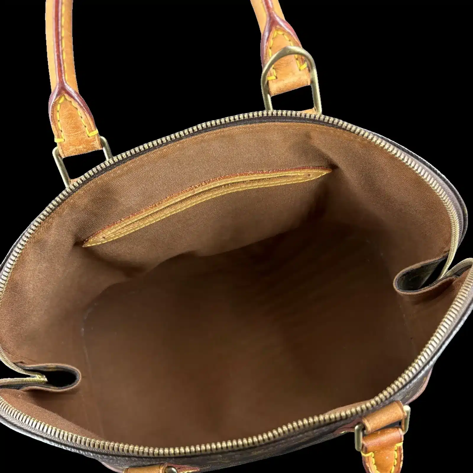 Intérieur du sac Louis Vuitton Alma, doublure en toile marron et poche plaquée en cuir