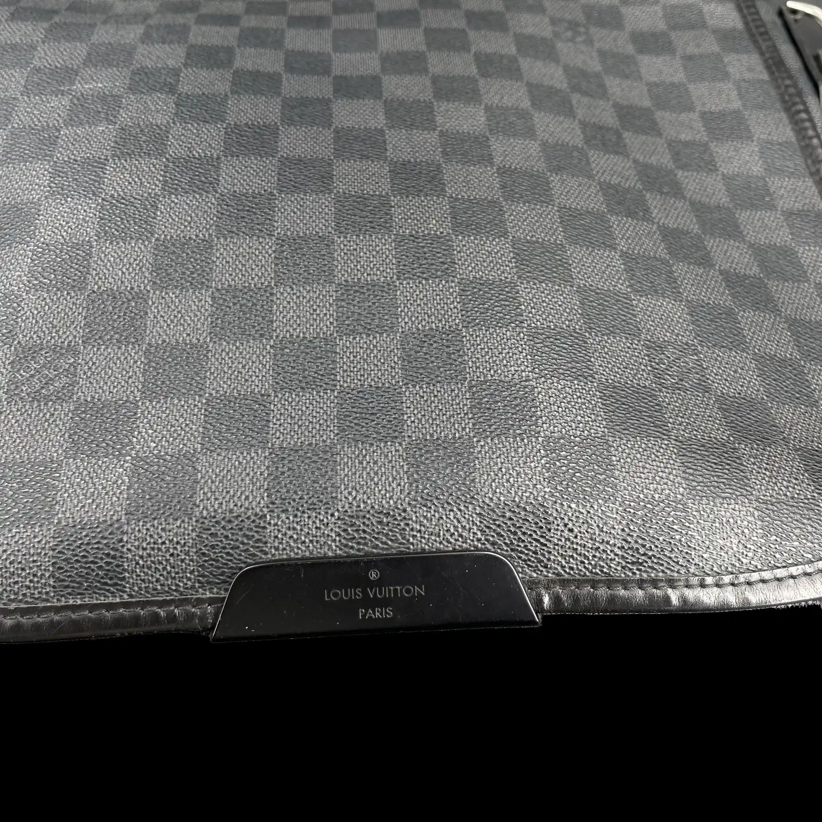 Détail de la plaque en cuir Louis Vuitton Paris du sac District MM