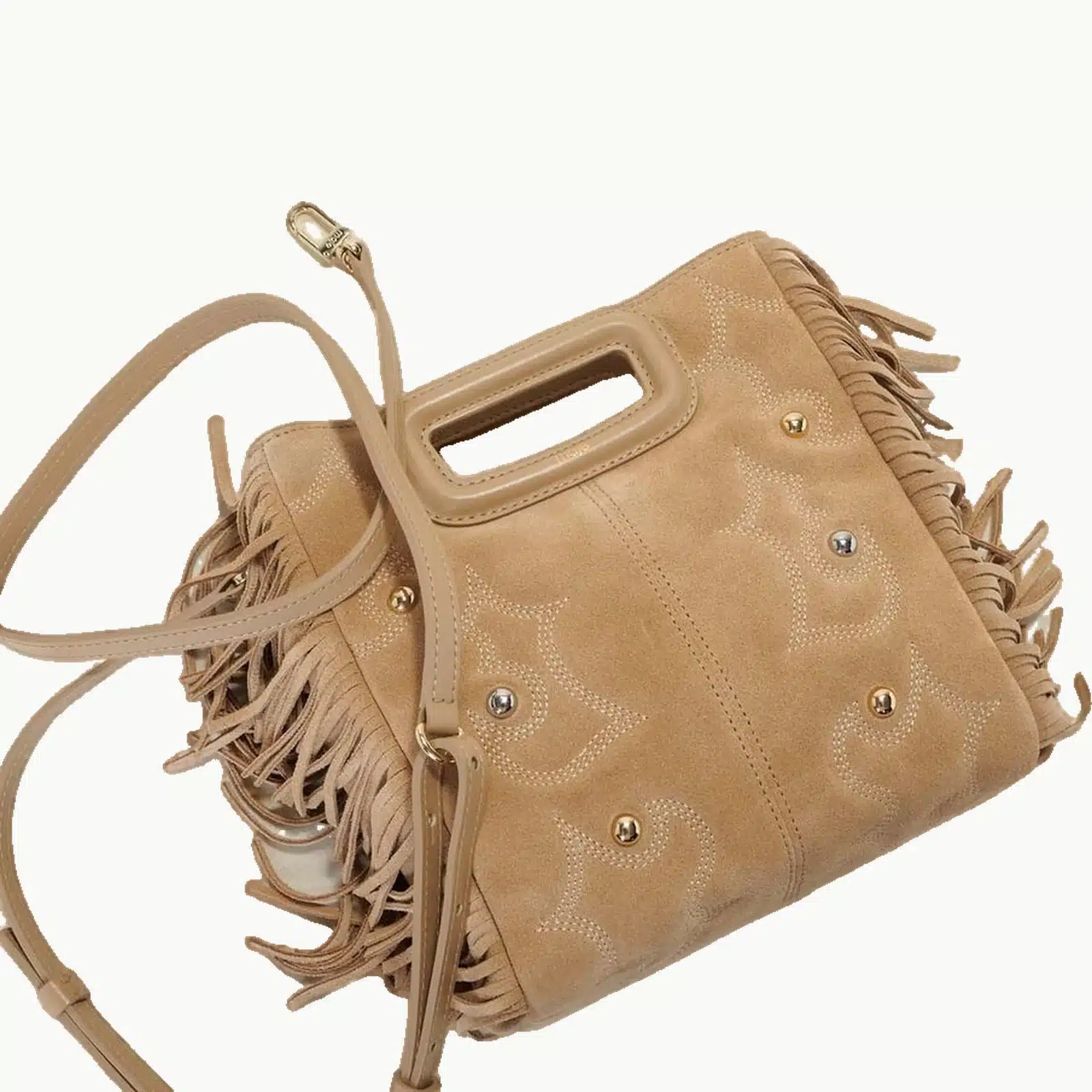 Sac Maje M beige à franges posé avec sa bandoulière en cuir et ses mousquetons dorés